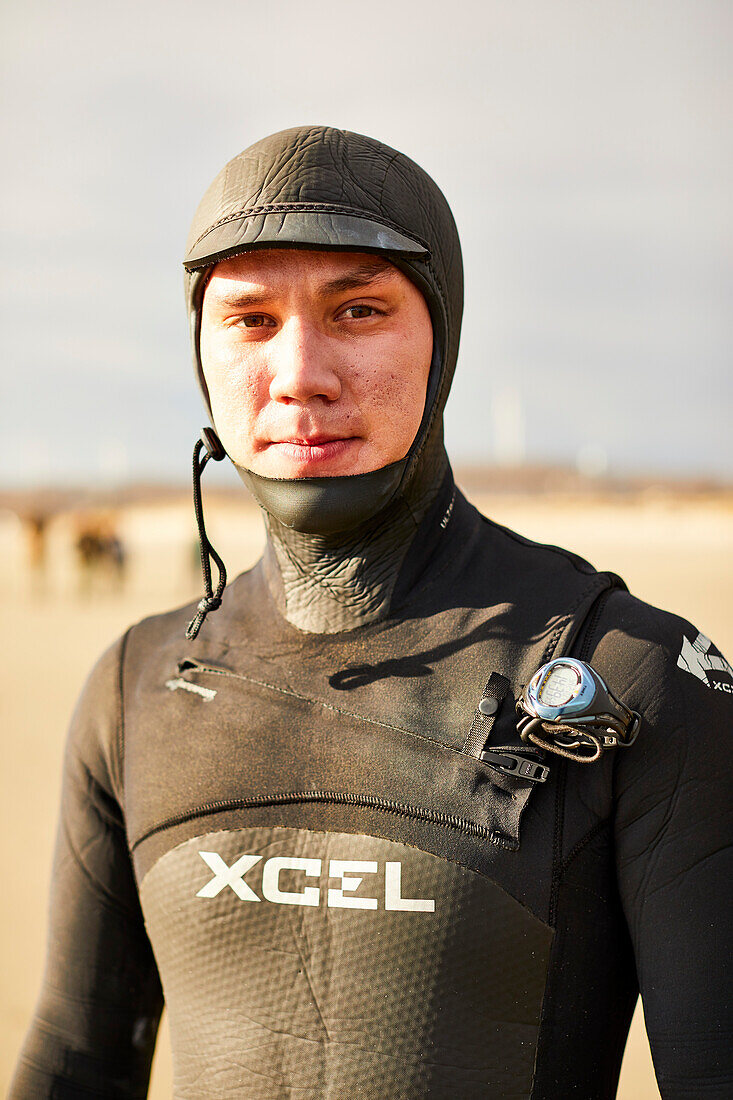 A portrait of a male surfer in his wetsuit