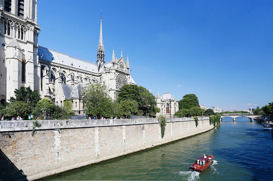 France, Paris, 4th arrondissement, Ile de la Cite, Notre-Dame Cathedral. Recreational boat sailing on the Seine.