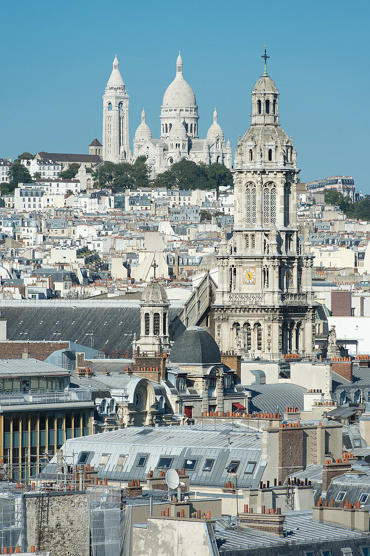 France. Paris 9th district. Bell tower of the Sainte Trinité church and the Sacre-Cœur Basilica