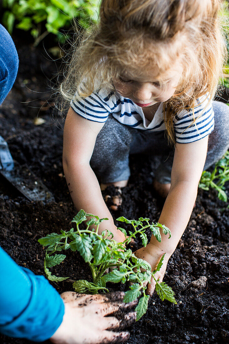 Caucasian mother teaching gardening to daughter