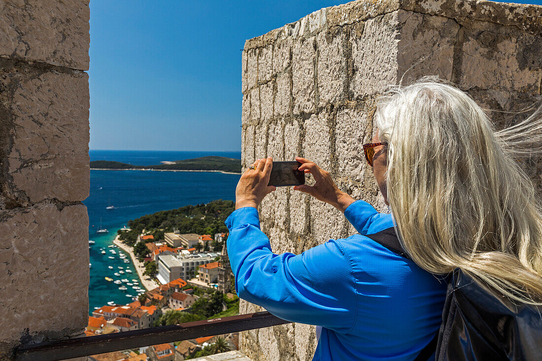 Caucasian woman photographing scenic view of ocean