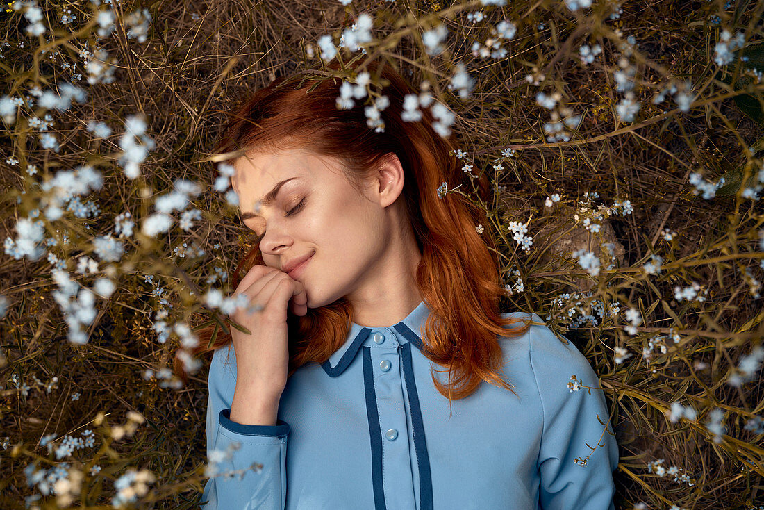 Caucasian woman laying in field of wildflowers