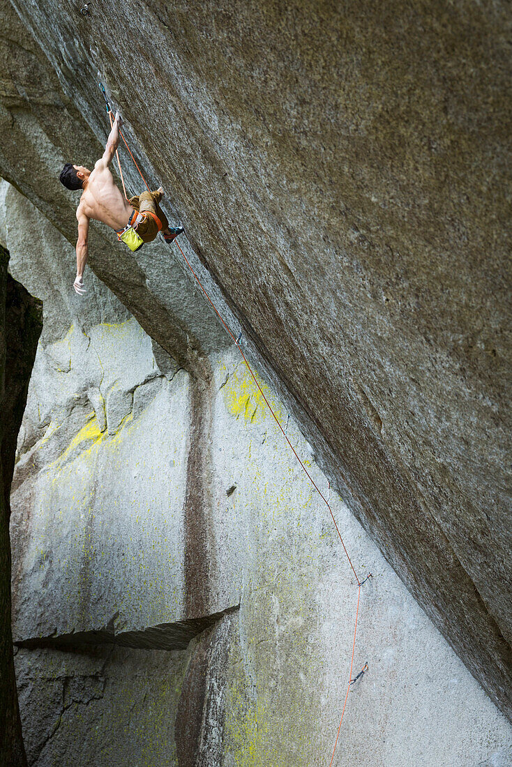 Mixed race boy rock climbing