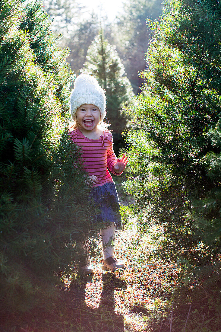 Excited Caucasian girl standing near trees