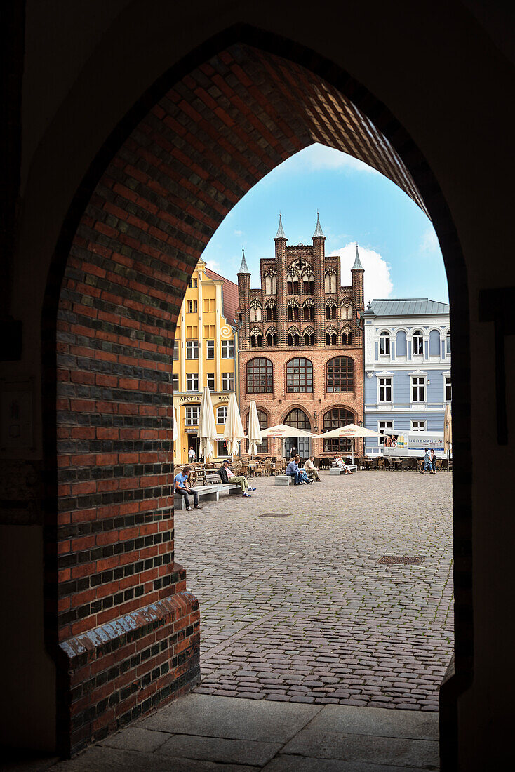UNESCO World Heritage Hanseatic city Stralsund, view through gothic brick archway towards market square, Mecklenburg-West Pomerania, Germany, Baltic Sea