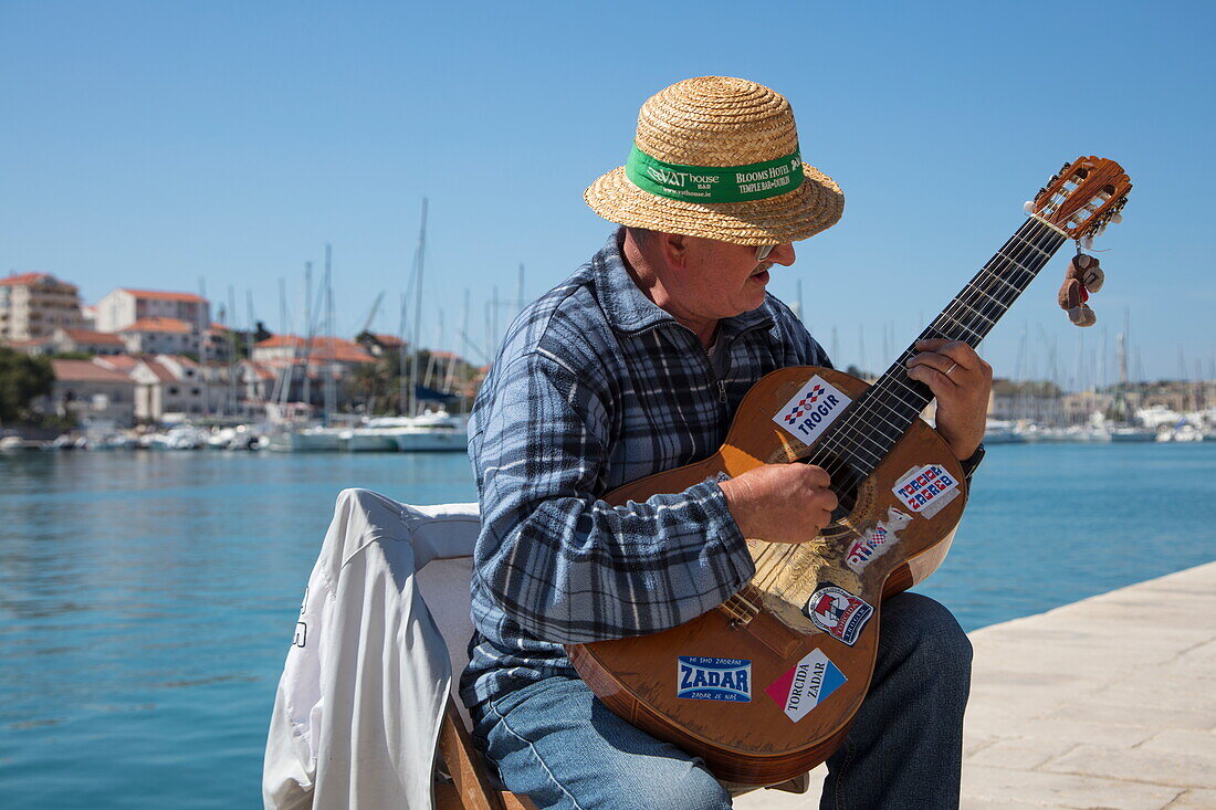 Straßenmusiker spielt Gitarre an der Strandpromenade, Trogir, Split-Dalmatien, Kroatien, Europa