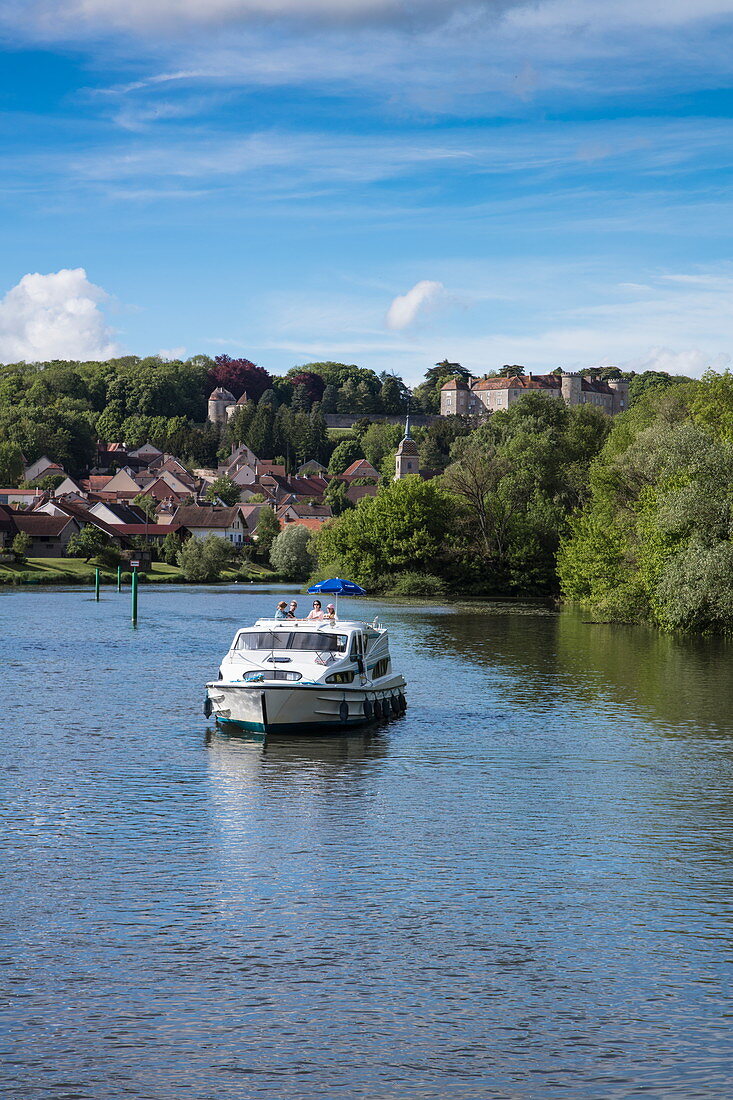 Le Boat Magnifique houseboat during cruise on Petit Saône river with town and Château Ray-sur-Saône castle behind, Ray-sur-Saône, Haute-Saône, Bourgogne-Franche-Comté, France