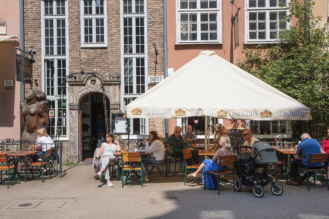 People sit outside at restaurant in Old Town, Gdansk, Pomerania, Poland