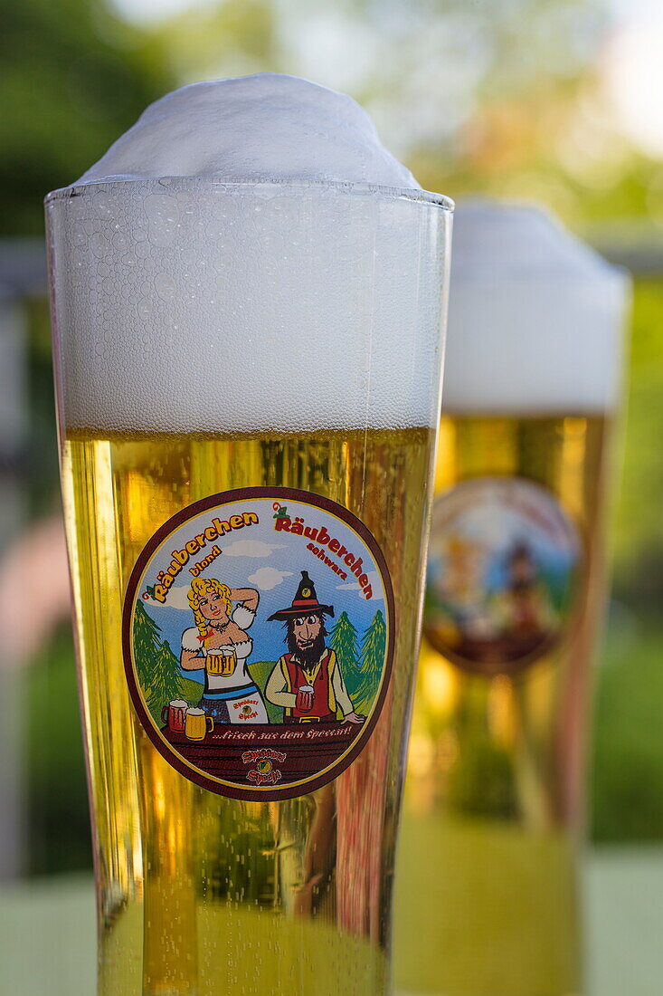 Two glasses of Räuberchen Blond beer brewed by Spessart Specht on terrace of Heimathenhof hotel and restaurant, Mespelbrunn Heimbuchenthal, Räuberland, Spessart-Mainland, Franconia, Bavaria, Germany