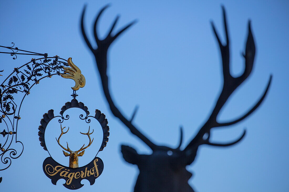 Sign for Jägerhof Hotel and seen through antlers, Weibersbrunn, Spessart-Mainland, Franconia, Bavaria, Germany