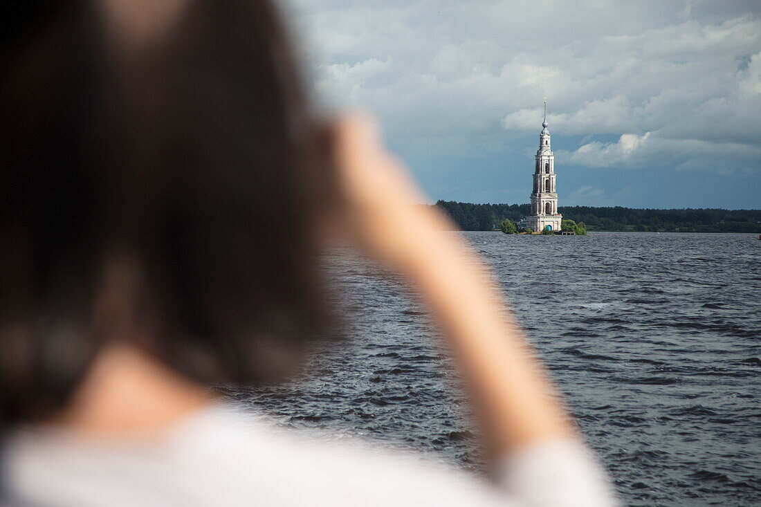 Frau fotografiert Glockenturm der gefluteten Nikolaus-Kathedrale am Fluss Wolga, Kaljasin, Russland, Europa