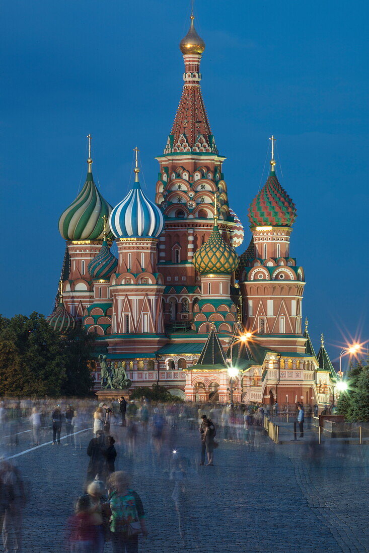 Menschen am Roten Platz und beleuchtete Basilius-Kathedrale in der Abenddämmerung, Moskau, Russland, Europa