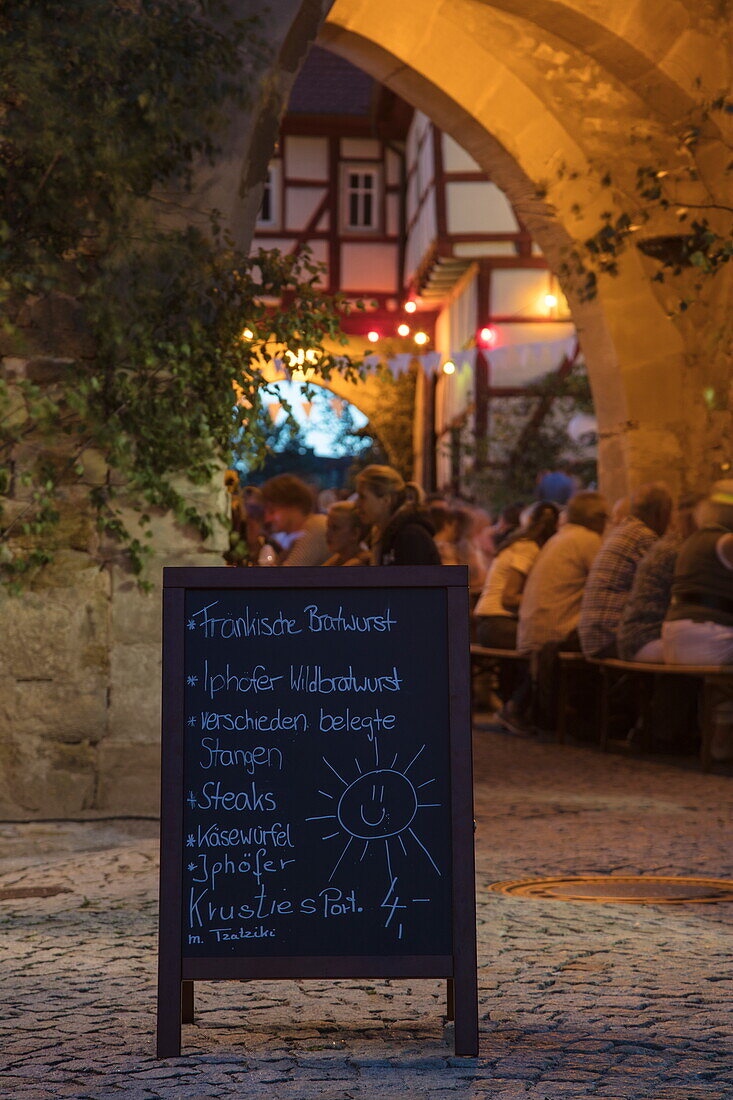 Schild mit Speisekarte beim Weinfest am Rödelseer Tor in der Abenddämmerung, Iphofen, Fränkisches Weinland, Franken, Bayern, Deutschland, Europa