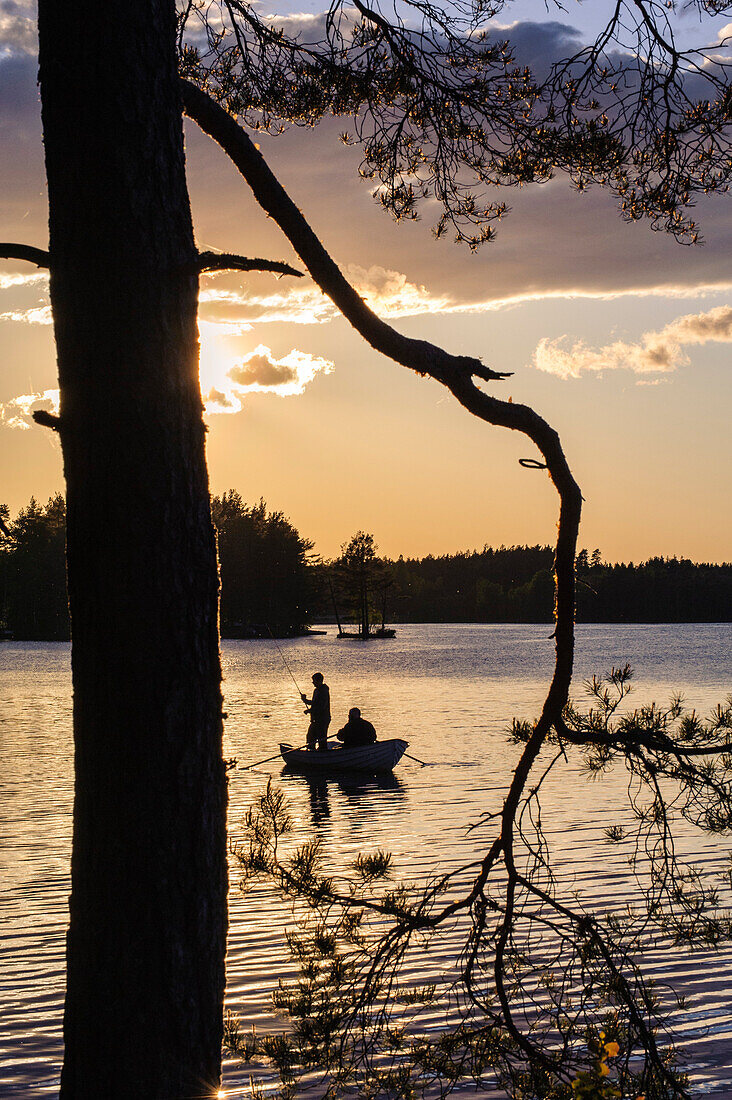 Angler im Ruderboot auf einem See mit kleinen Inseln , Schweden