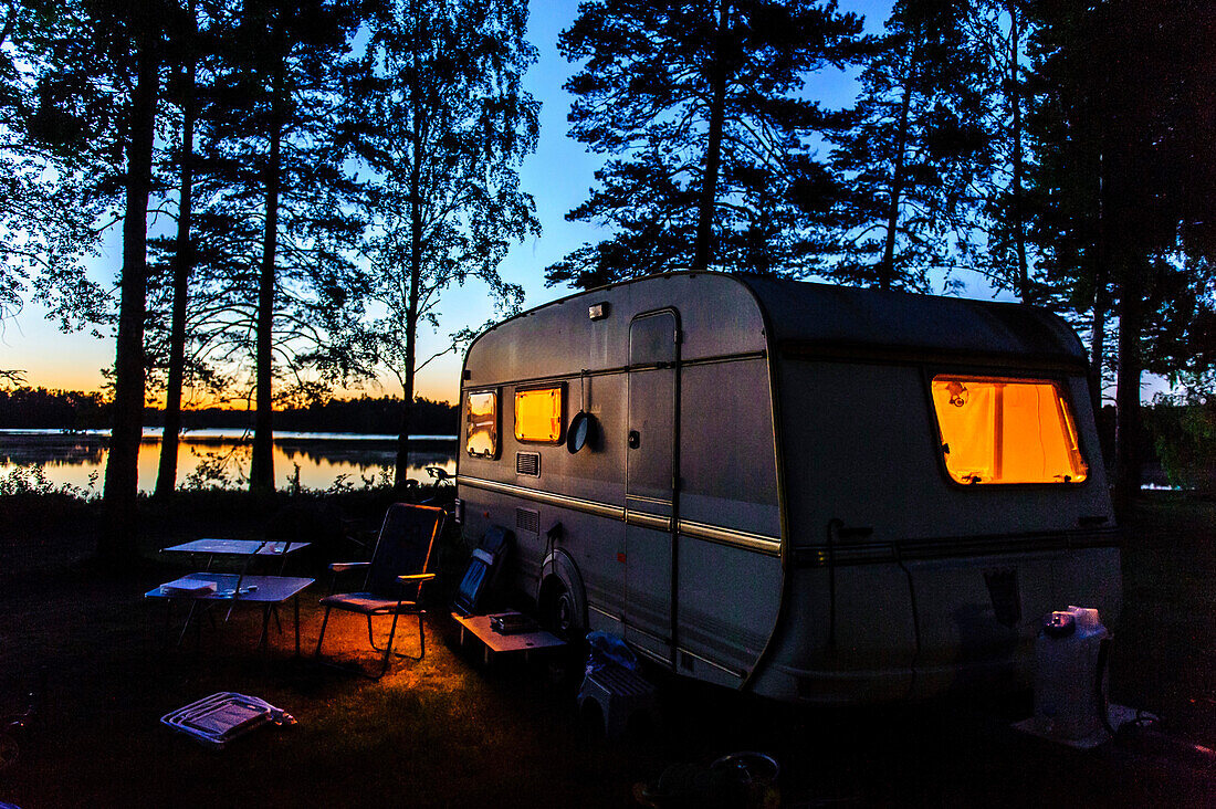 Wohnwagen im Abendlicht an einem See , Schweden