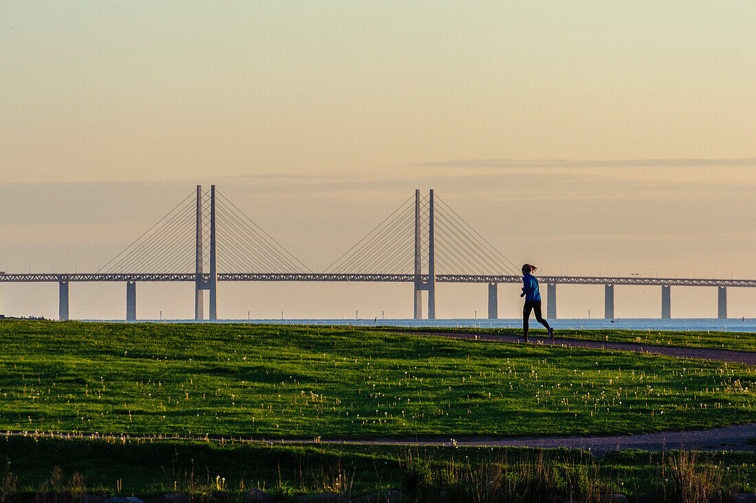 Frau joggt an der Küste bei Malmo, Oeresundbrücke, Südschweden, Schweden