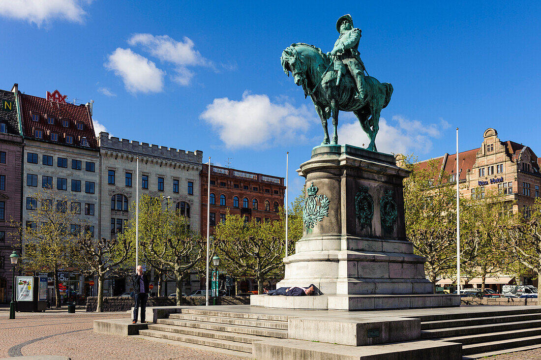 Mann schlaeft vor Reiterstatue Koenig Karl Gustav X., Marktplatz Stortorget mit Rathaus, Malmö, Südschweden, Schweden