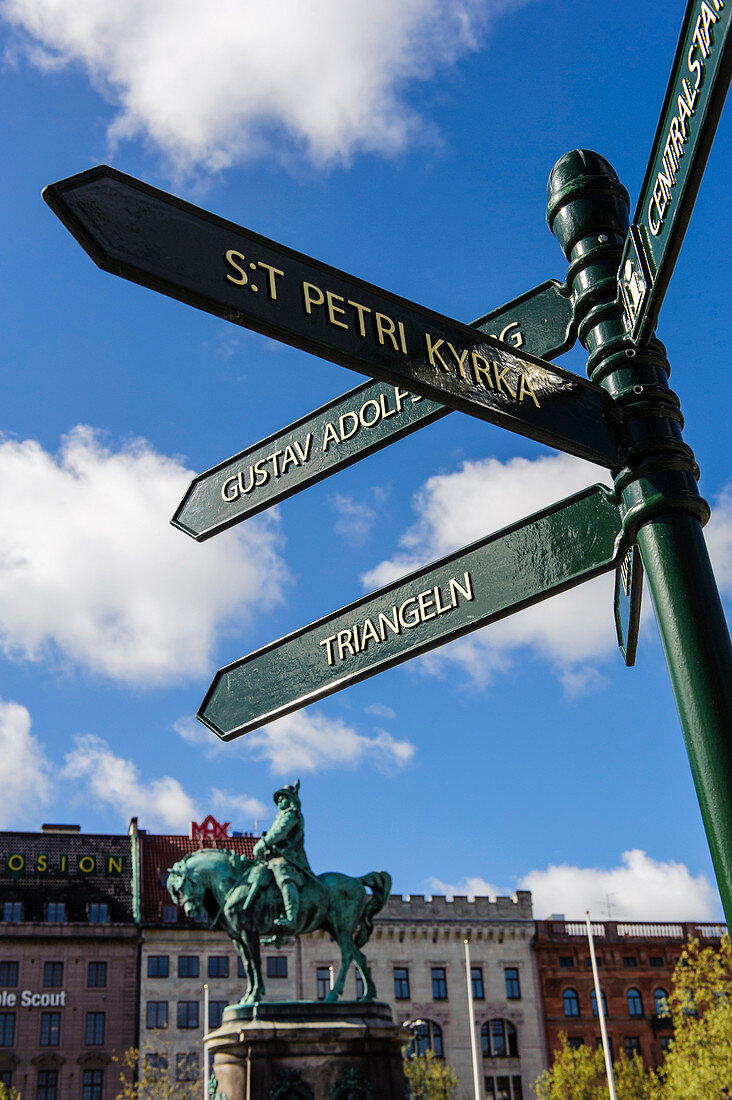 Signpost with rider statue King Karl Gustav X on the market square Stortorget with town hall, Malmö, southern Sweden, Sweden