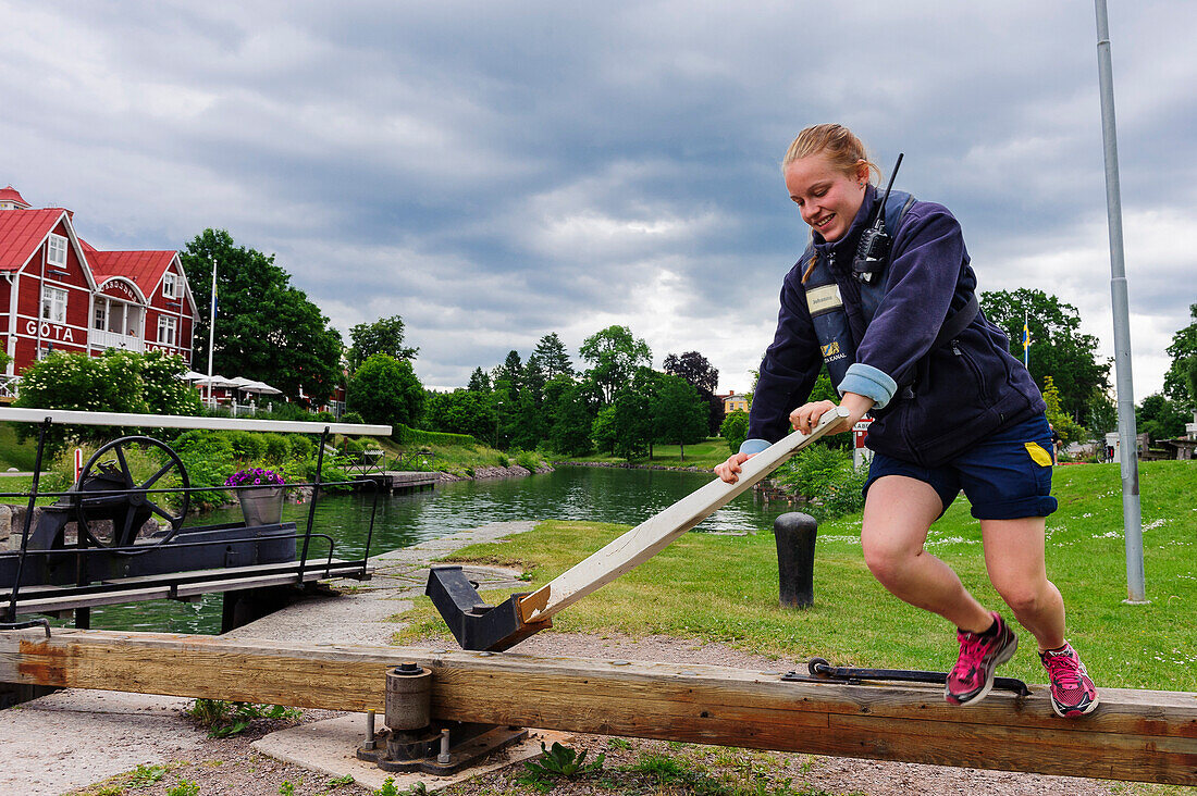 Schleusenwaerter bei der Arbeit, kleine Schleusentreppe bei Borensberg, Goeta Hotel im Hintergrund , Schweden