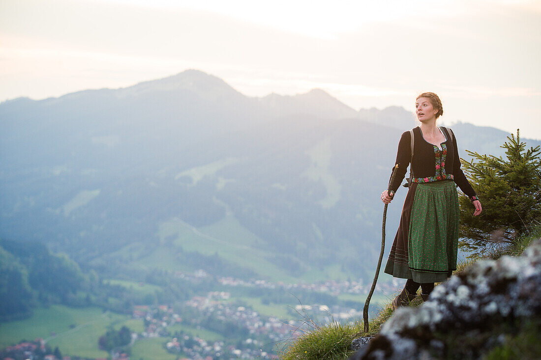 Junge Frau in Tracht wandert auf dem Falkenstein im Allgäu, Pfronten, Bayern, Deutschland