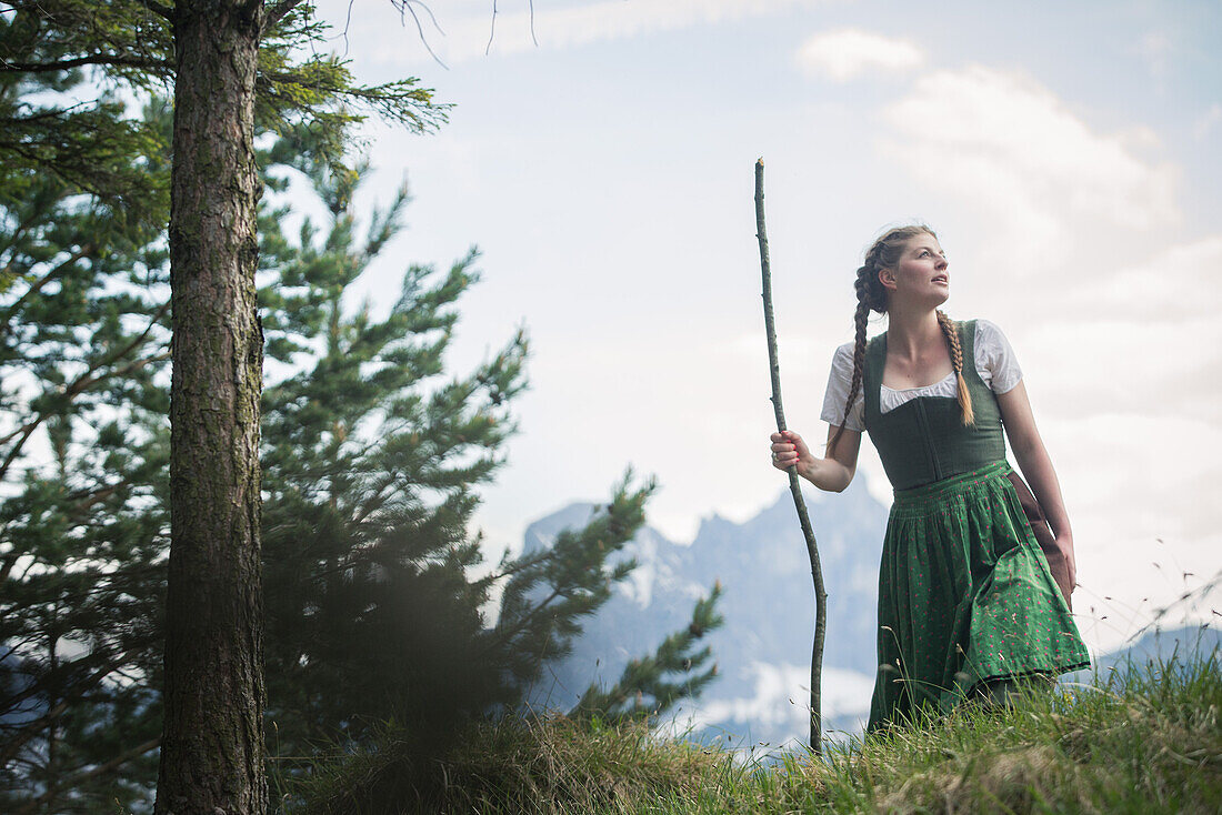 Junge Frau in Tracht wandert durch die Wälder auf dem Falkenstein, Pfronten, Bayern, Deutschland