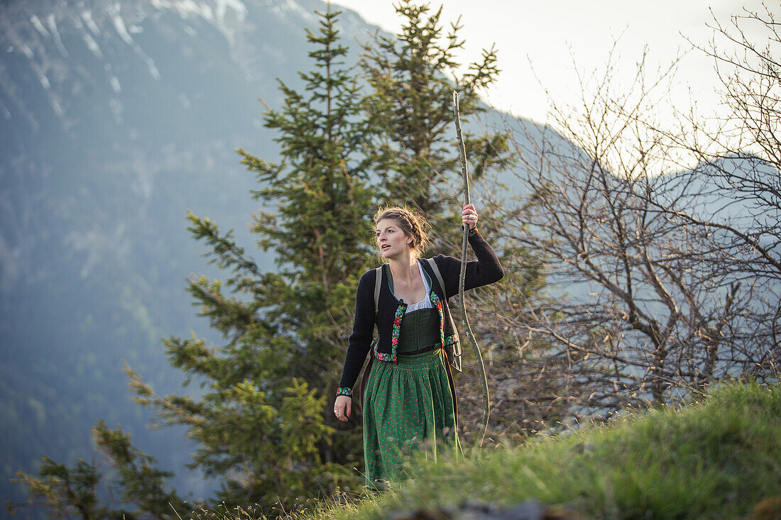 Young woman in traditional costume hiking on Falkenstein in Allgaeu, Pfronten, Bavaria, Germany