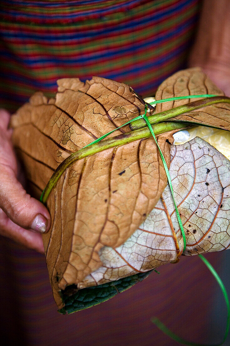 Woman holding wrapped organic leaves