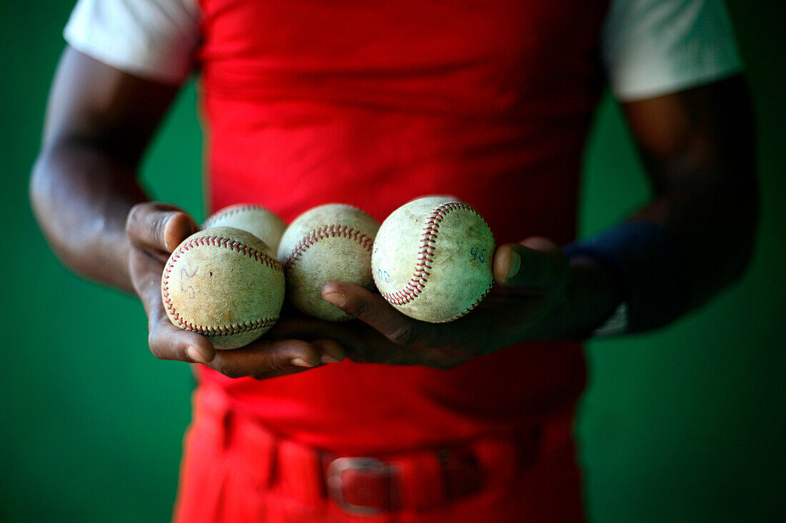 Baseball player holding baseballs