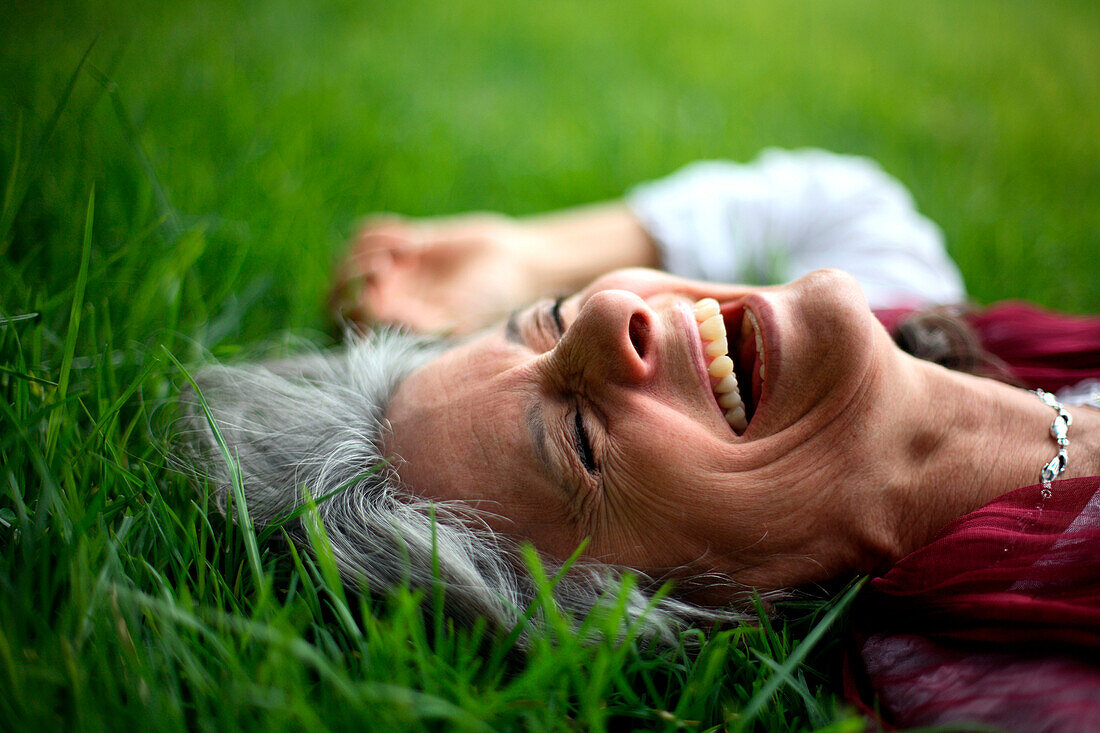 Laughing Caucasian woman laying in grass