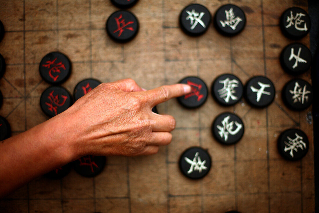 Hand moving game piece on wooden board