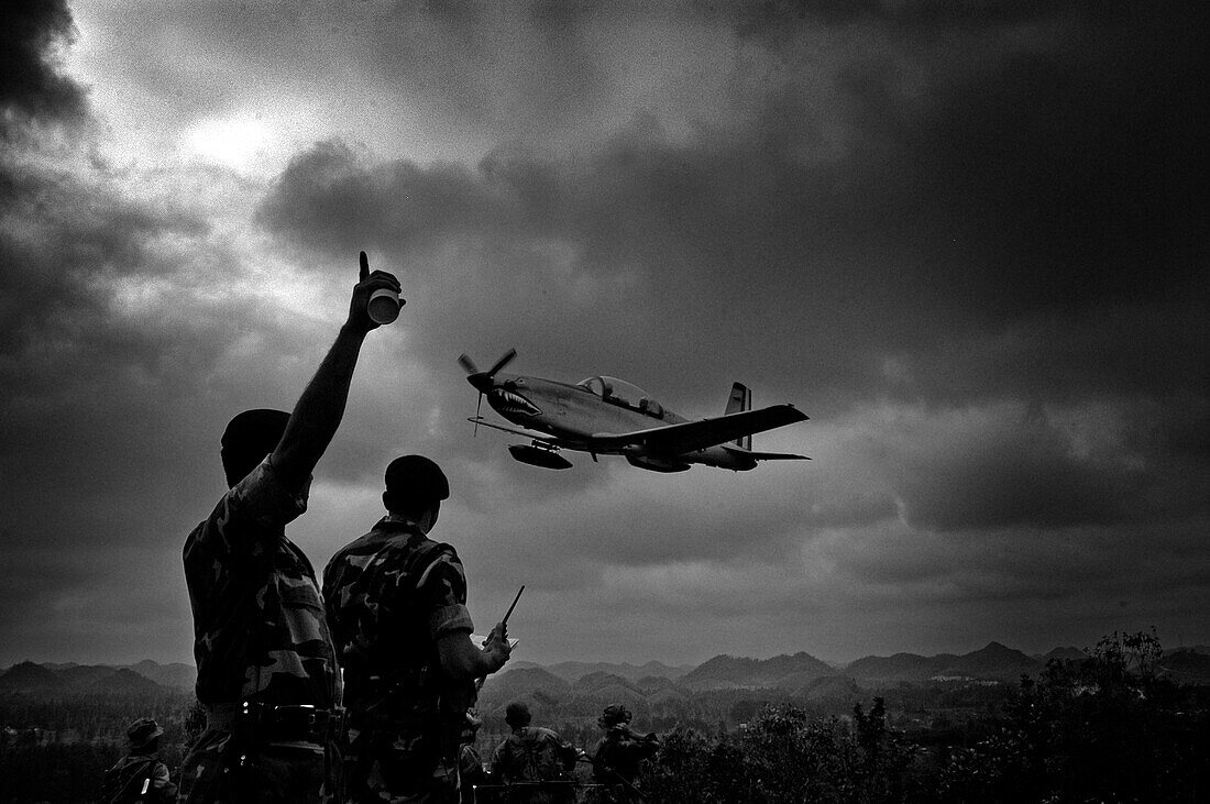 Soldiers pointing to flying old-fashioned airplane