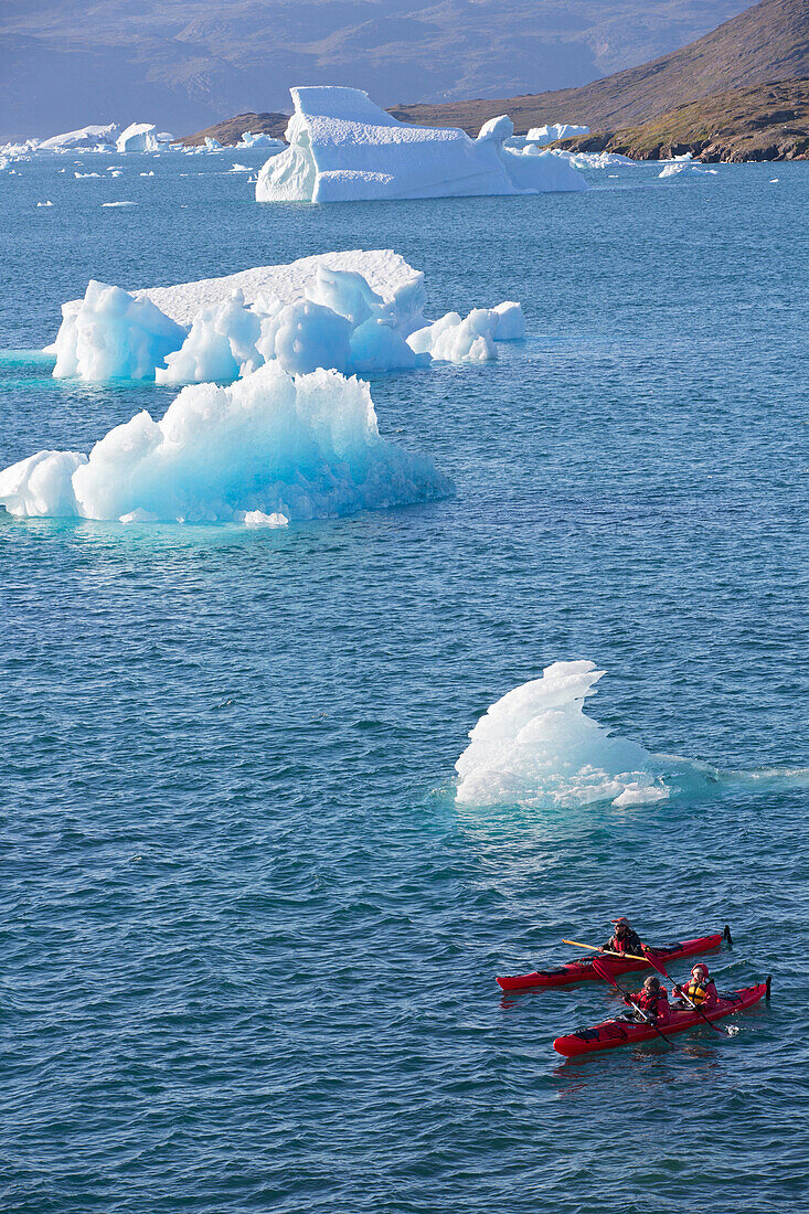 kayaking in the middle of the icebergs that separated from the glacier, fjord of narsaq bay, greenland