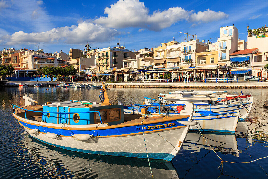 Small fishing boats reflected in Voulismeni Lake, Agios Nikolaos, Lasithi, Crete, Greek Islands, Greece, Europe