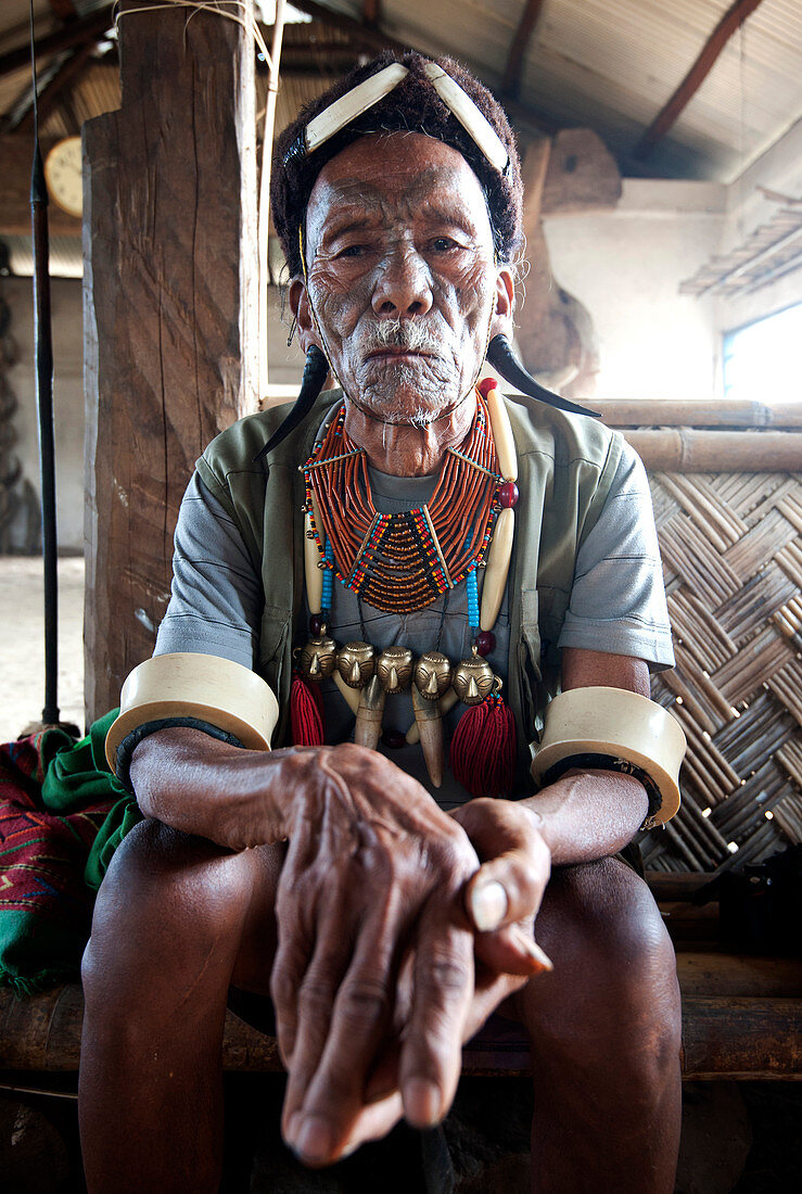 Gangchung Wangben, Naga man, headhunter, wearing horn earrings, Naga necklaces with brass heads and elephant tusk arm bands, Nagaland, India, Asia