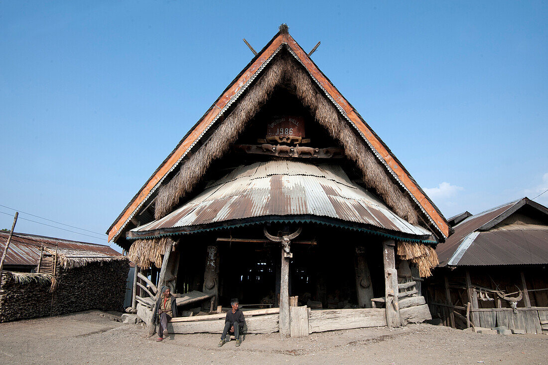 Village men sitting outside Naga village murung (village meeting hall) with traditional Naga decoration, Nagaland, India, Asia