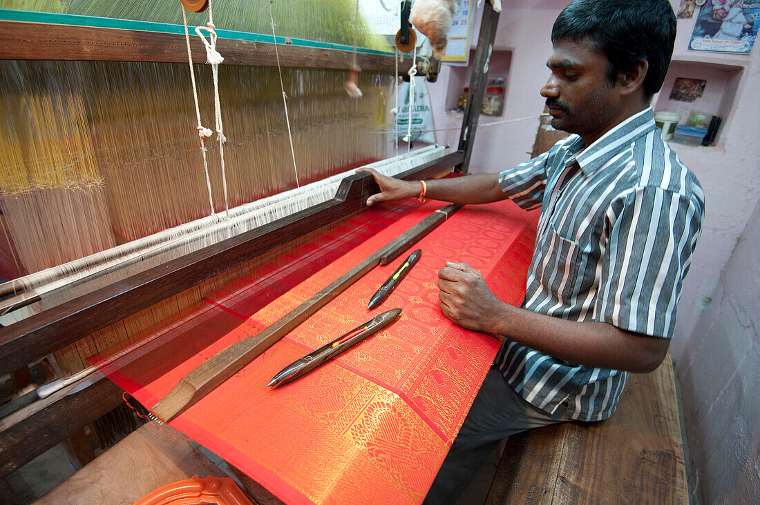 Silk weaver at his loom in his house, weaving sought after red and gold Kanchipuram silk sari, Kanchipuram, Tamil Nadu, India, Asia