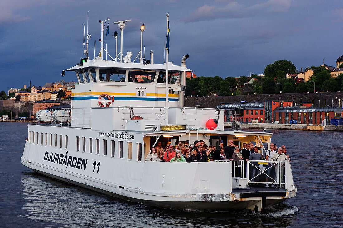 Blick auf Soedermalm, Fähre mit vielen Menschen im Vordergrund , Stockholm, Schweden