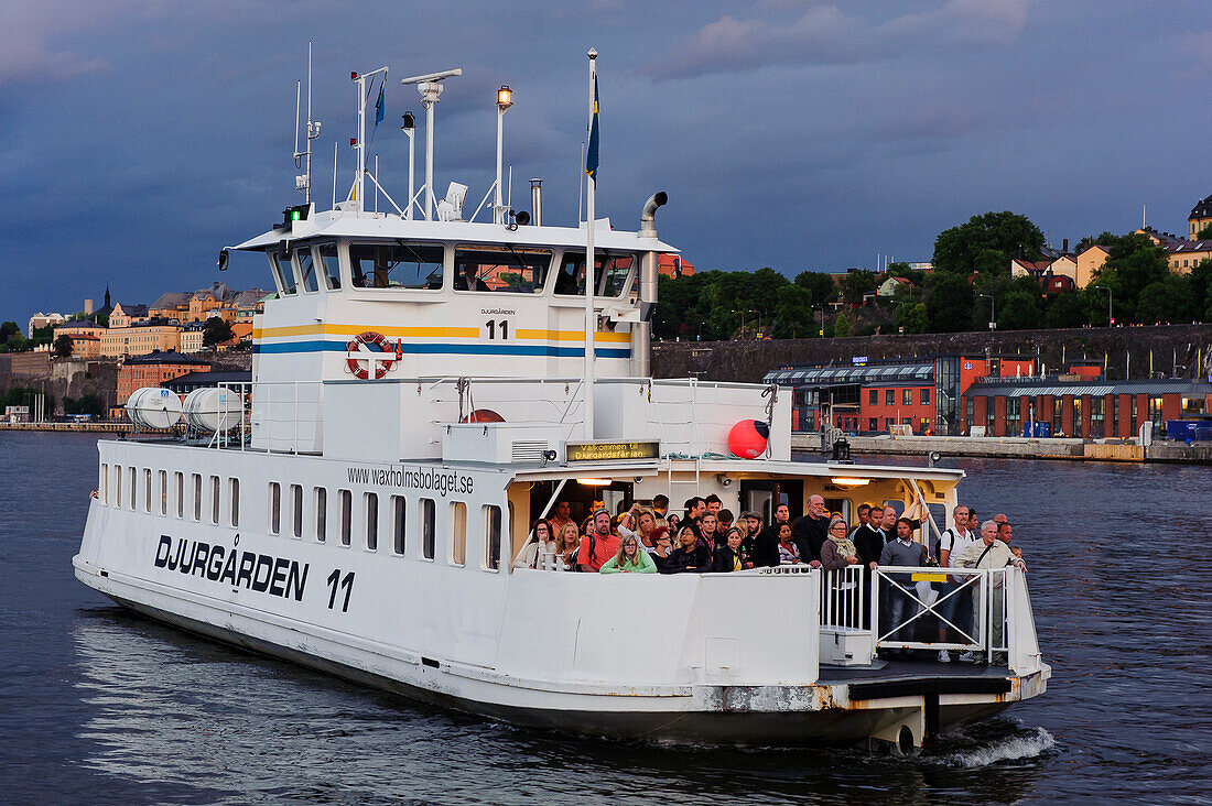 View of Soedermalm, ferry with many people in the foreground, Stockholm, Sweden
