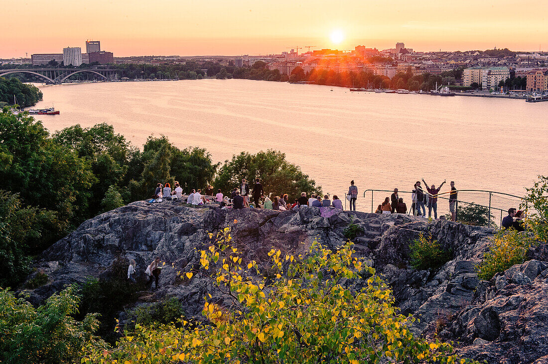 Blick von Soedermalm Skinnerviksparken, Menschen geniessen den Sonnenuntergang , Stockholm, Schweden