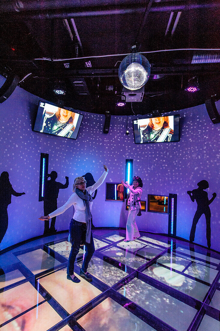Tourists dance to Abba music in the Abba Museum, Stockholm, Sweden