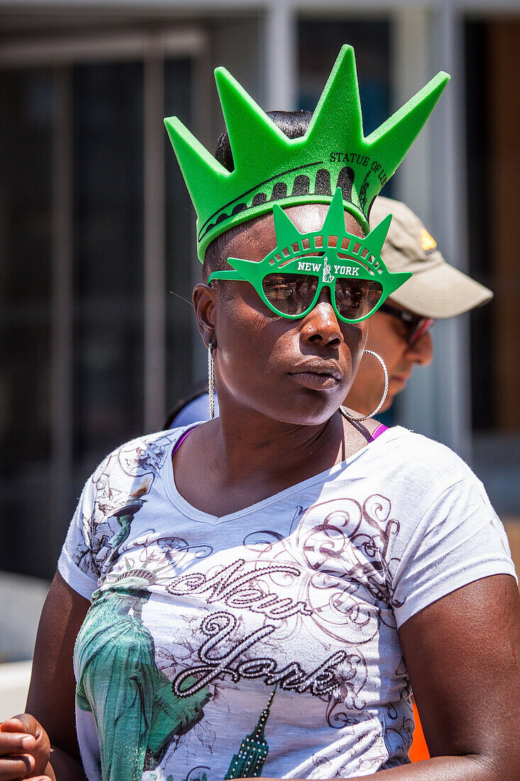 young black american girl wearing sunglasses and a styrofoam crown in the colors of the statue of liberty, financial district, downtown, manhattan, new york city, state of new york, united states, usa