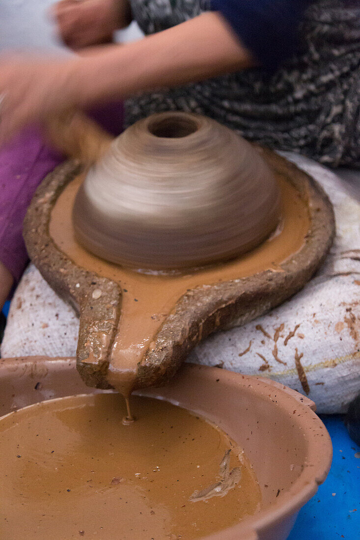 the nut of the argan will be ground by the traditional press to extract the oil, the women's cooperative of marjana, traditional manufacturing of argan oil and cosmetics, essaouira, mogador, atlantic ocean, morocco, africa