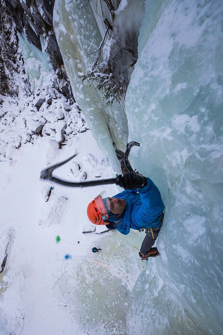 climber/mountaineer planting his ice axe in an ice cascade, golsjuvet falls, gol, region of hemsedal, buskerud, norway