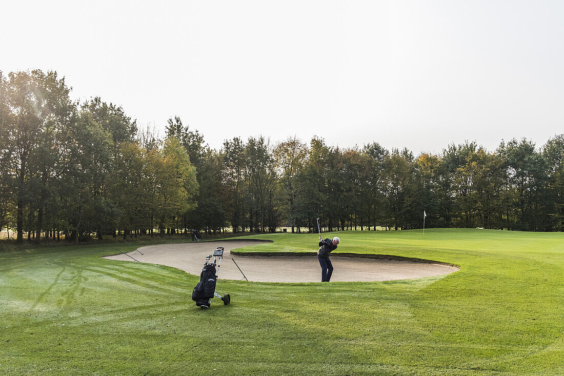 golf player in a sand bunker on a golf course near Hamburg, north Germany, Germany