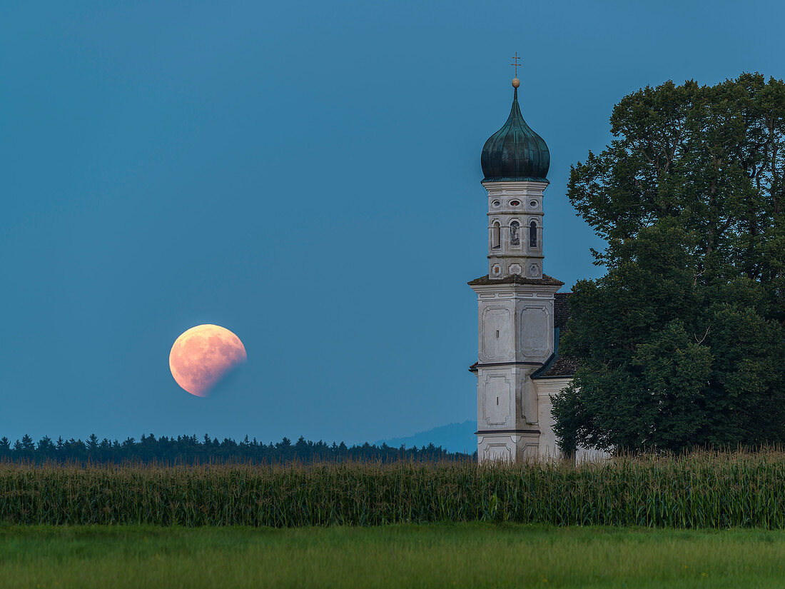 partial lunar eclipse at the St Andreas chapel soth of Weilheim, Bavaria, Germany