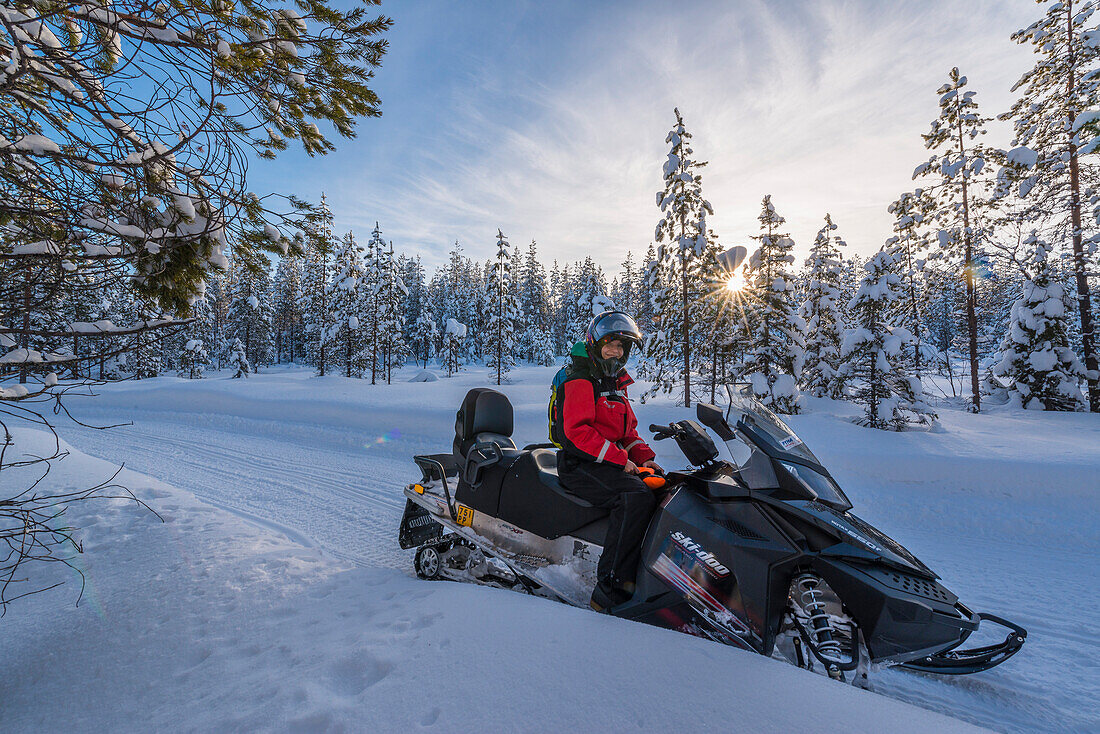 driving with a snowmobile at low light near Pyhä, Pyhä-Luosto National park, finnish Lapland