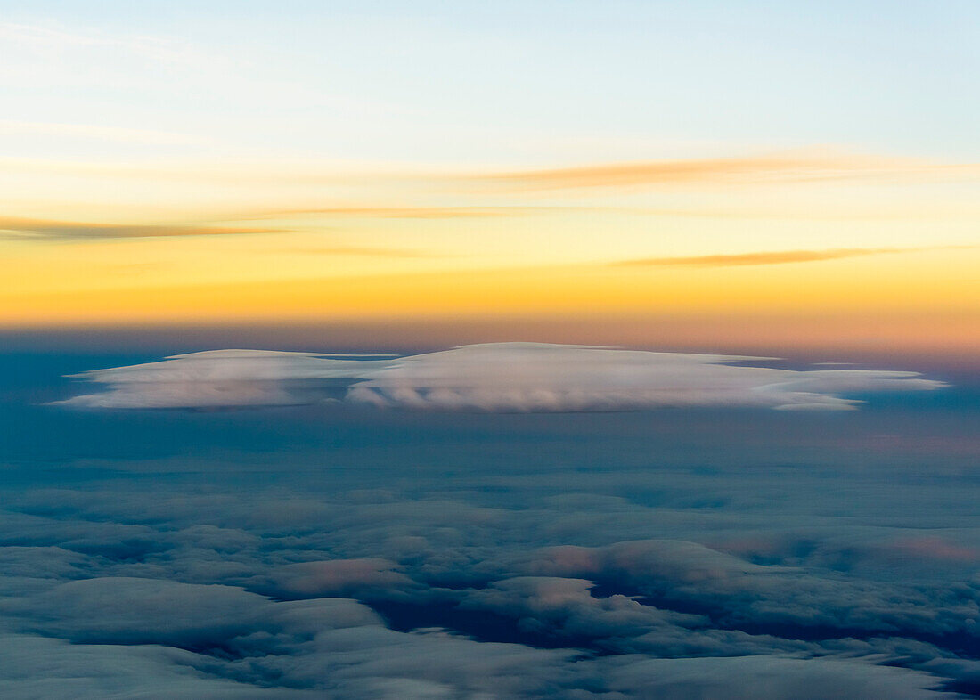 Luftaufnahme einer Lenticularis Wolke vor orangenem Himmel