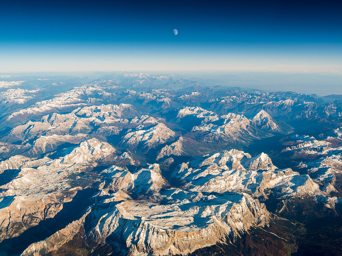 aerial picture during sunset with the moon above dolomites,  Venetia, Italy