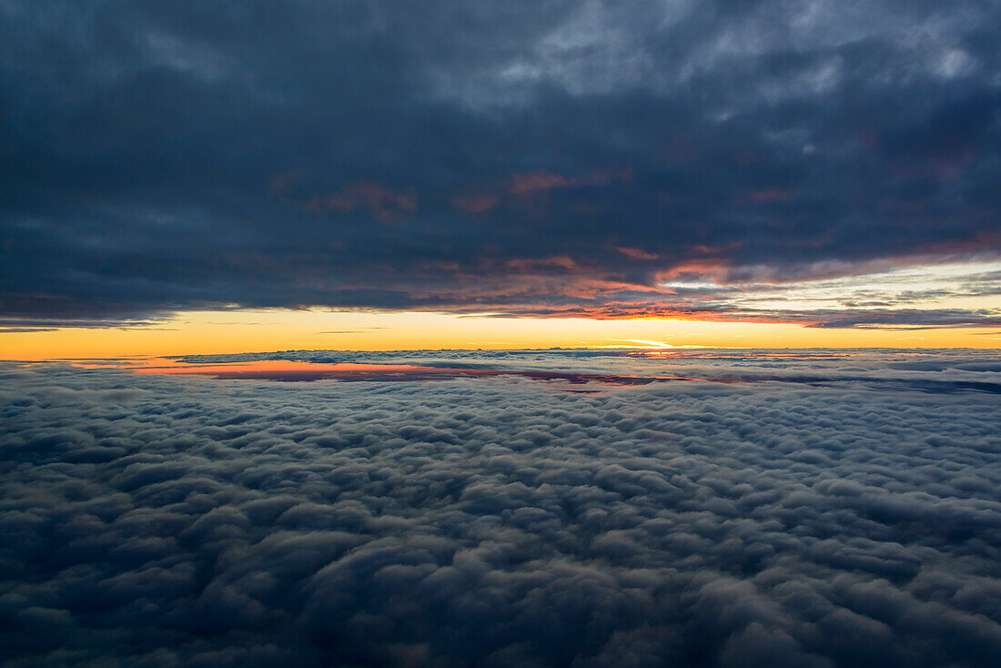 Luftaufnahme eines Sonnenuntergangs zwischen zwei Wolkenschichten
