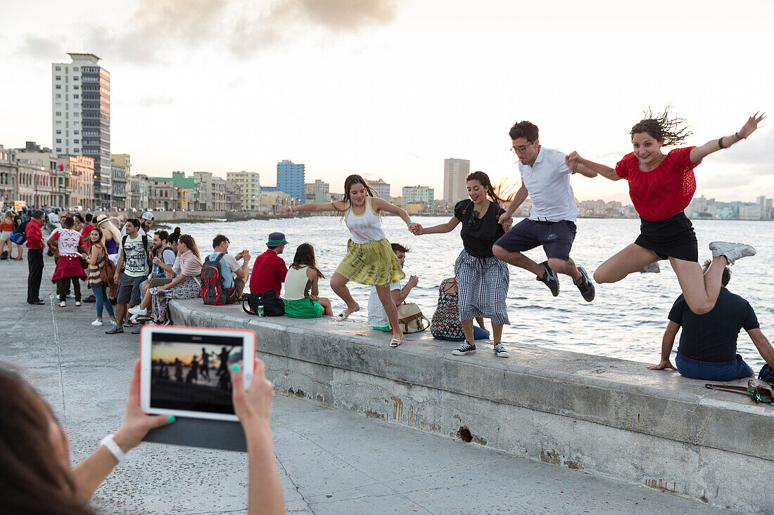 tourists and local people and fisherman at Malecon, woman taking pictures with tablet, historic town, center, old town, Habana Vieja, Habana Centro, family travel to Cuba, holiday, time-out, adventure, Havana, Cuba, Caribbean island